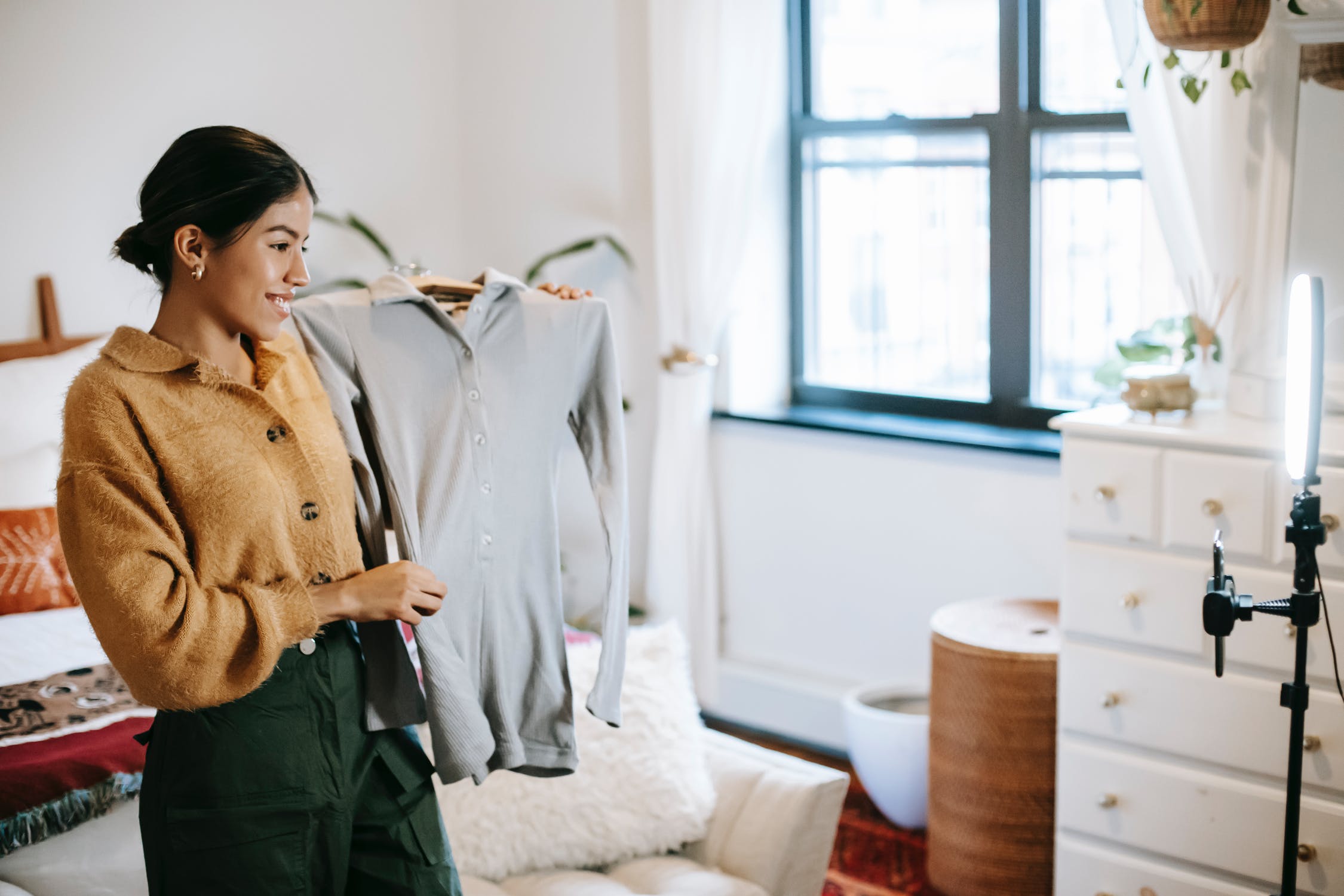 A girl taking photos of herself with her new clothing from an online purchase